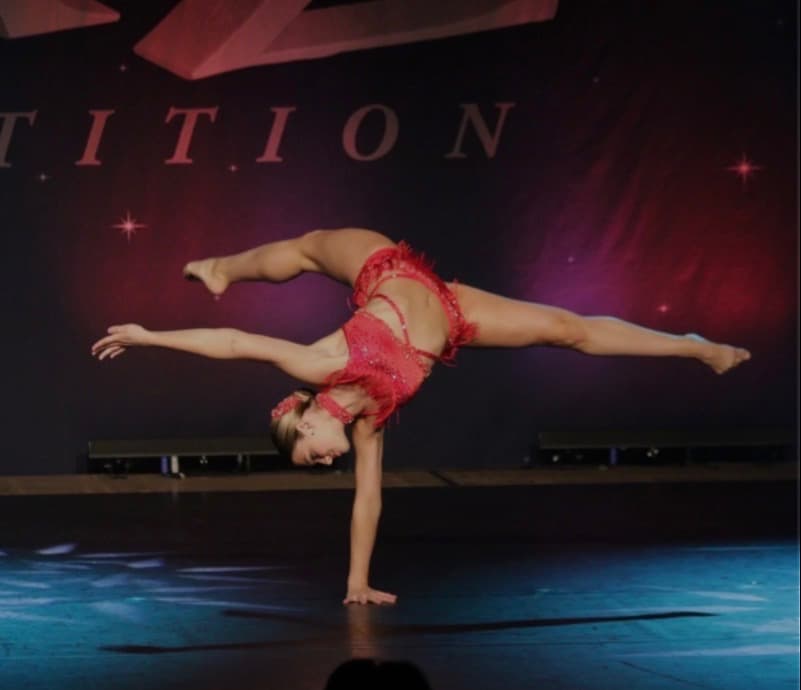 Faith performing a dance pose on stage